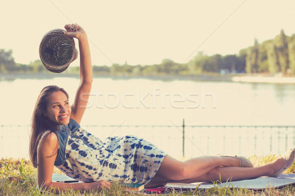 young woman laying in a meadow in front of a lake Stock photo © ichiosea