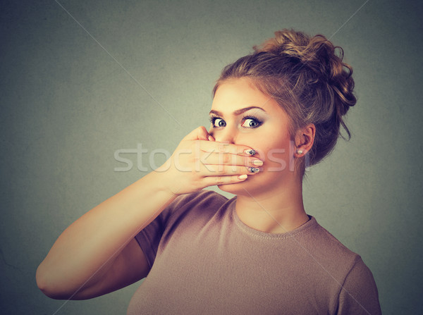 Stock photo: scared young woman covering with hand her mouth 