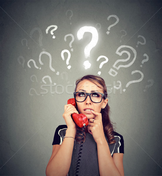 Misunderstanding and distant call. Upset worried confused woman talking on a phone has many question Stock photo © ichiosea