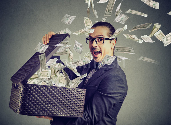 Excited successful man opening a box with money flying out away  Stock photo © ichiosea