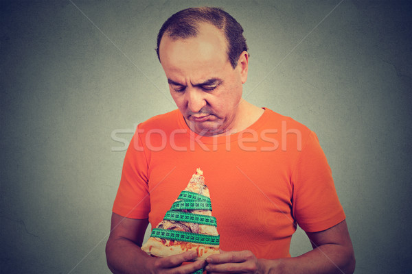 middle aged man eating craving a pizza. Unhealthy eating diet nutrition concept Stock photo © ichiosea