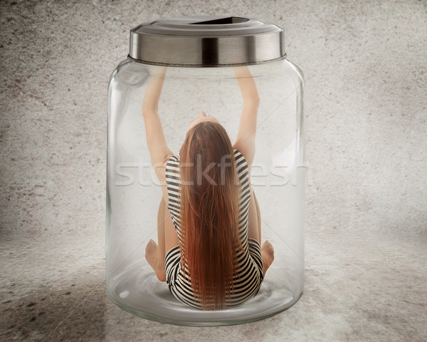 Stock photo: Young lonely woman sitting in glass jar 