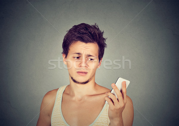 annoyed man holding cellphone looking mad at stressful texts Stock photo © ichiosea