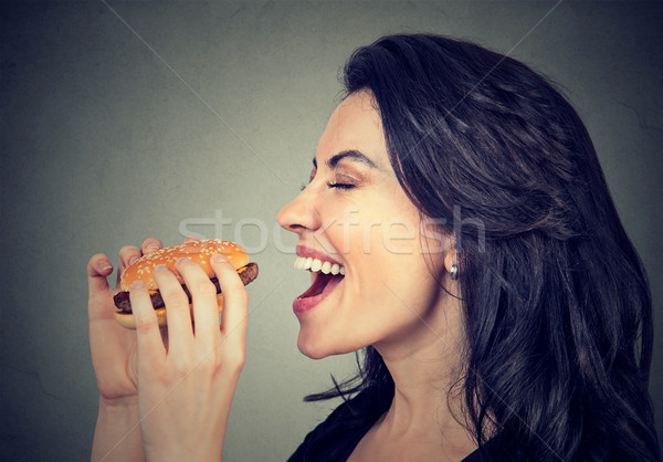 Side profile young woman eating a tasty burger 
 Stock photo © ichiosea