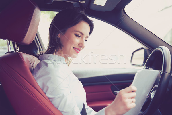 Transportation and ownership concept. Woman inside new car reading documents Stock photo © ichiosea