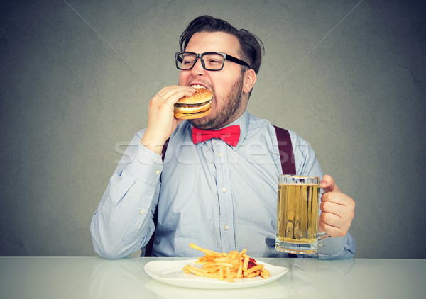 man eating junk food drinking beer Stock photo © ichiosea