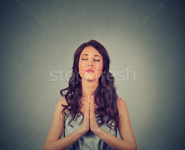 Young woman praying eyes closed isolated on gray wall background  Stock photo © ichiosea