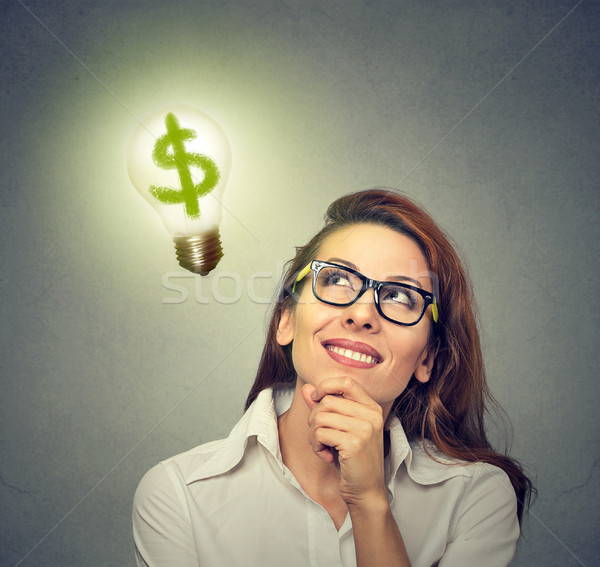 Business woman looking up at light bulb with dollar sign inside it  Stock photo © ichiosea