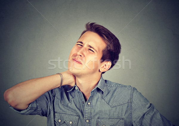 Stressed unhappy young handsome man with bad neck pain  Stock photo © ichiosea