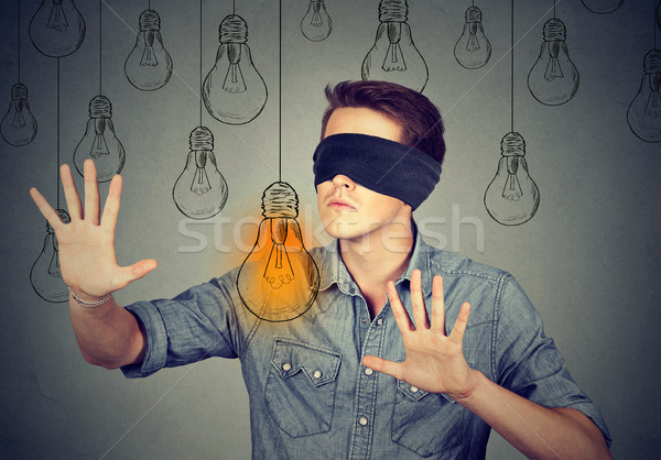 Blindfolded man walking through light bulbs searching for idea Stock photo © ichiosea