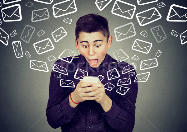 shocked man receiving messages from smartphone email icons flying away  Stock photo © ichiosea