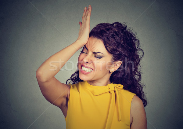 Regrets. Silly woman, slapping hand on head having duh moment  Stock photo © ichiosea