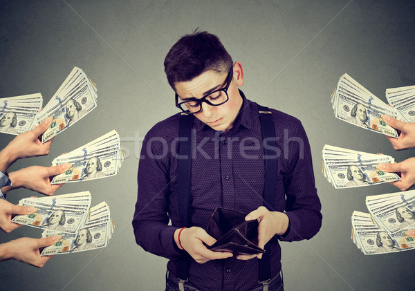 Sad man with empty wallet being offered money dollar banknotes   Stock photo © ichiosea