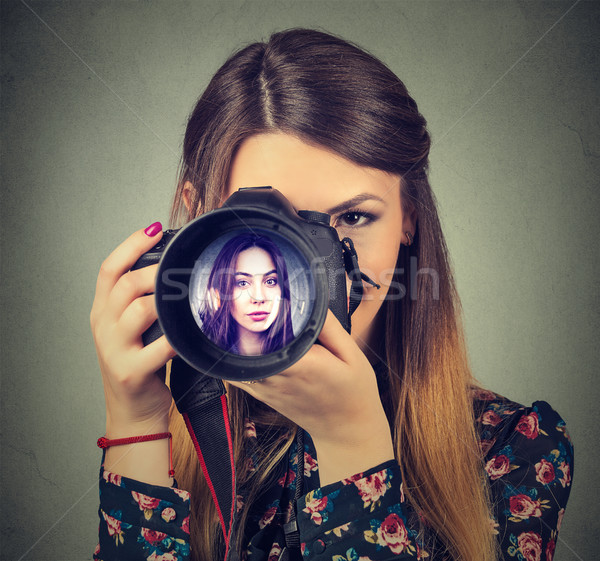 Professional photographer looking through a lens of a camera with beautiful woman in it Stock photo © ichiosea