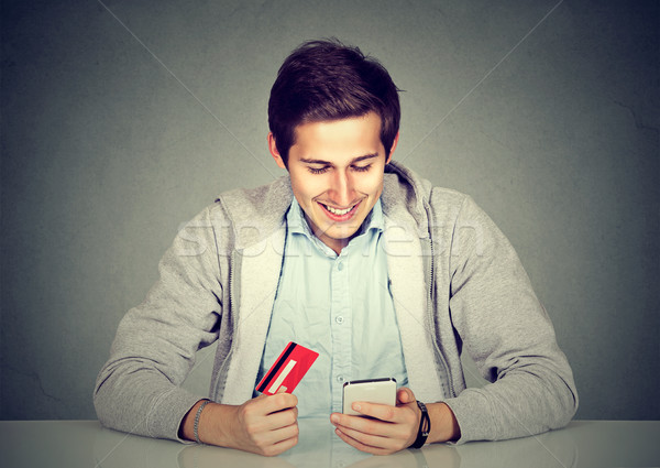 Man holding credit card using smart phone for internet shopping Stock photo © ichiosea