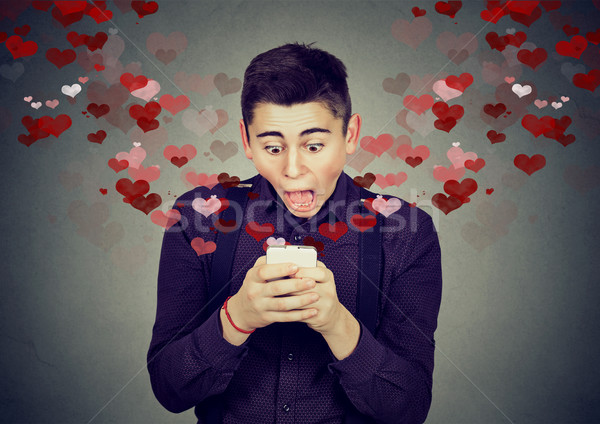 Stock photo: shocked man receiving love sms text message on mobile phone 