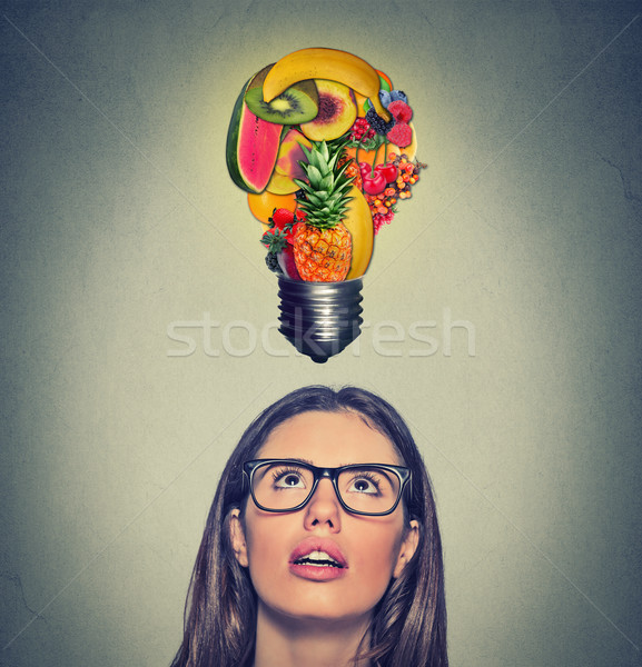 Eating healthy idea diet tips. Woman looking up light bulb made of fruits above head Stock photo © ichiosea