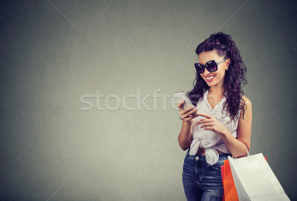 Beautiful woman shopping online checking prices on mobile phone. Stock photo © ichiosea