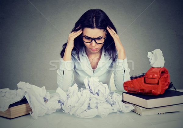 Too much work stressed woman sitting at her disorganized desk with books and many paper balls  Stock photo © ichiosea