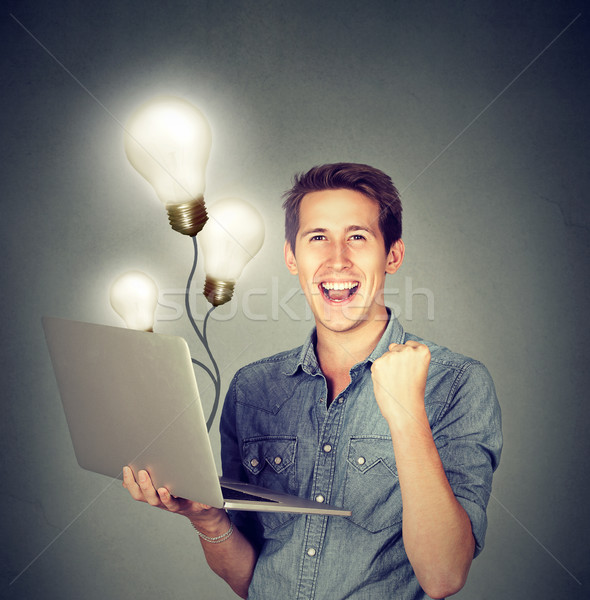 Man using a laptop with light bulbs plugged in it  Stock photo © ichiosea