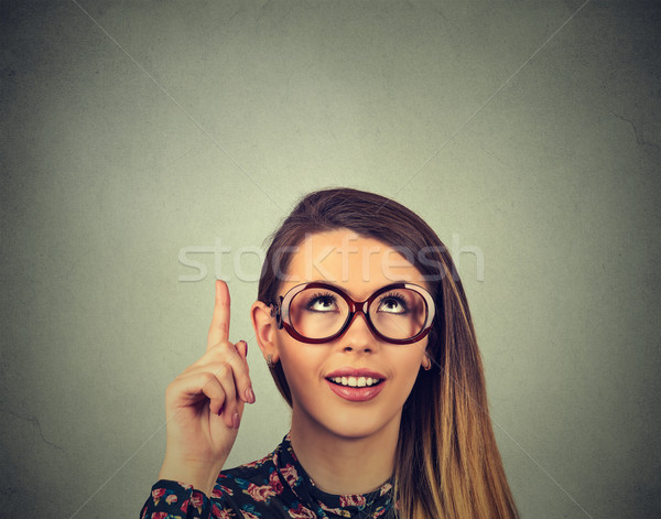 Business woman in glasses pointing with finger up has an idea smiling  Stock photo © ichiosea