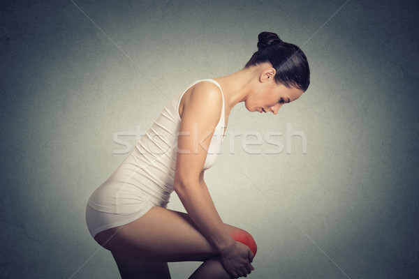 Side profile woman standing holding lifting  her painful knee co Stock photo © ichiosea