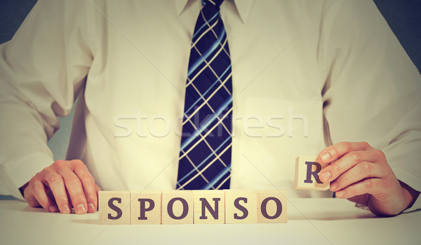 Businessman arranging wooden blocks on table. Business sponsor scholarship concept  Stock photo © ichiosea