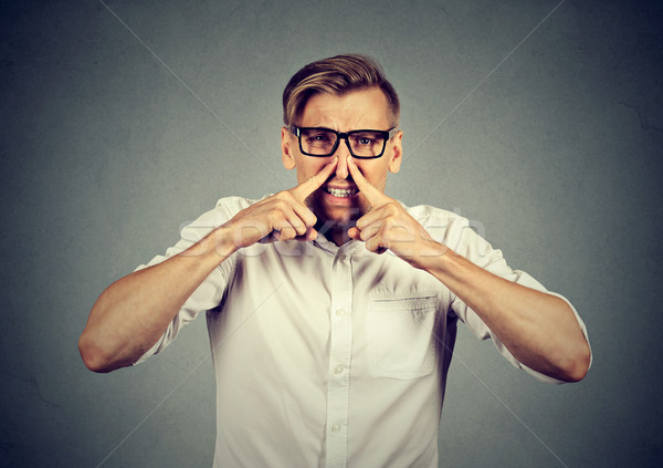 man pinches nose looks with disgust something stinks bad smell  Stock photo © ichiosea
