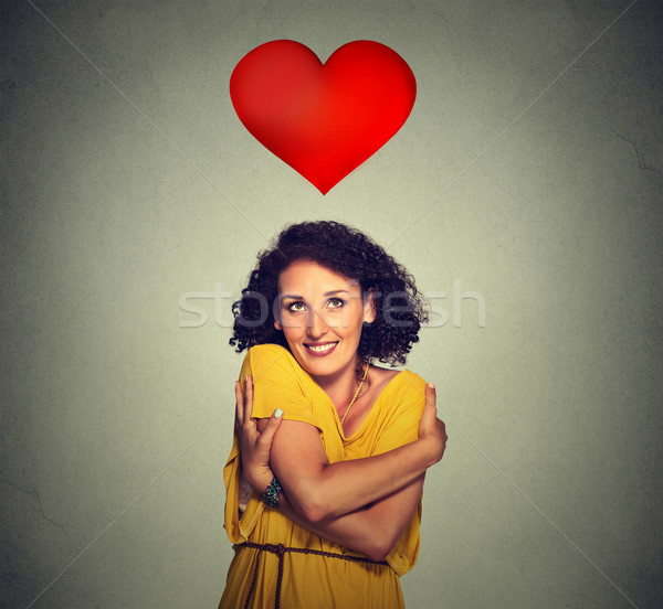 portrait smiling woman holding hugging herself with red heart above head  Stock photo © ichiosea