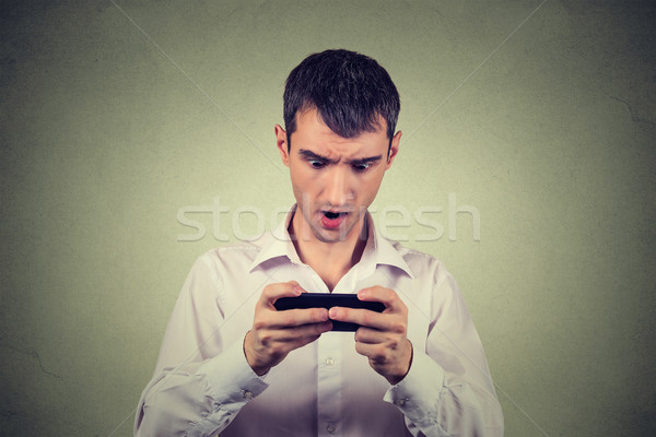 Nyugtalan megrémült fiatalember néz telefon rossz hírek Stock fotó © ichiosea