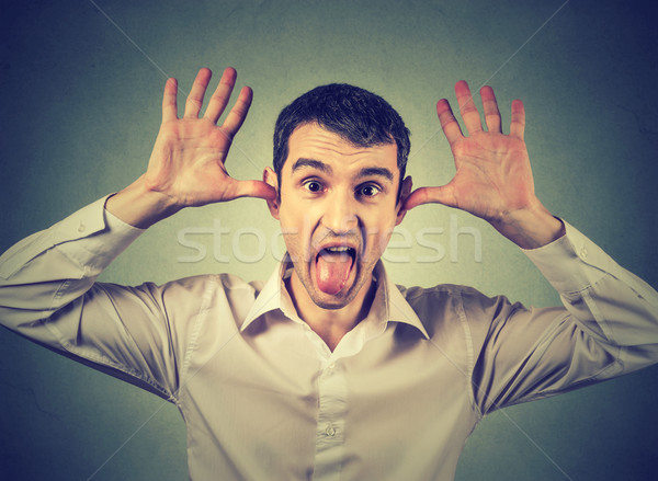 Young angry man, sticking out tongue at you, camera gesture Stock photo © ichiosea