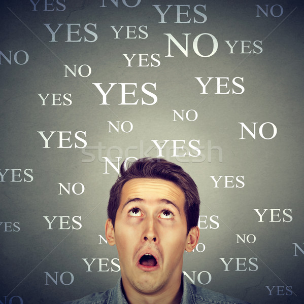 Stock photo: surprised perplexed man with yes or no choice looking up 