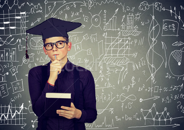 Man in graduation cap with book thinking about education Stock photo © ichiosea