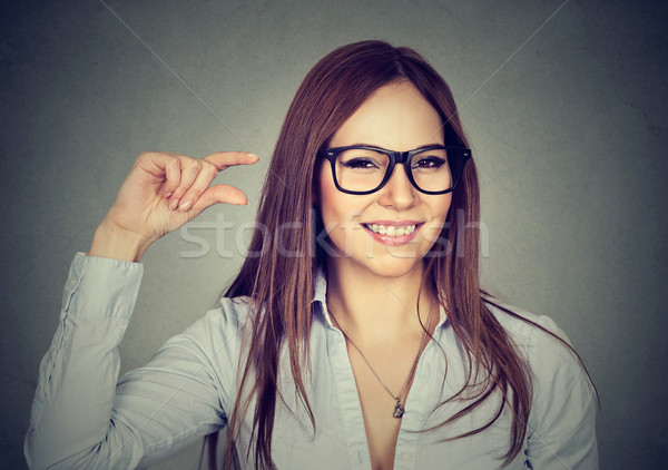 Stock photo: Woman showing small amount size gesture with hand fingers