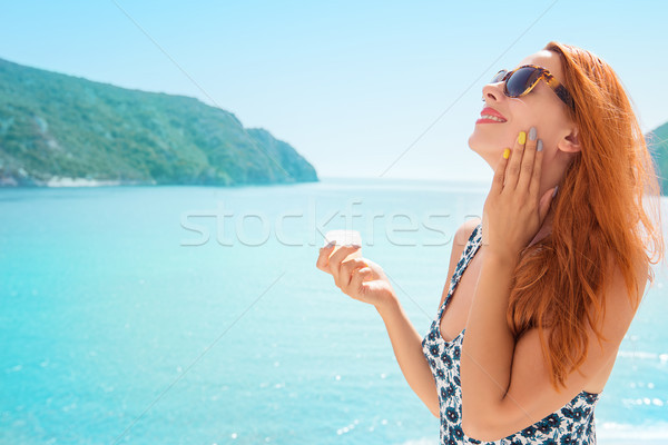 Stock fotó: Fiatal · nő · jelentkezik · napozókrém · testápoló · vízpart · mosolyog