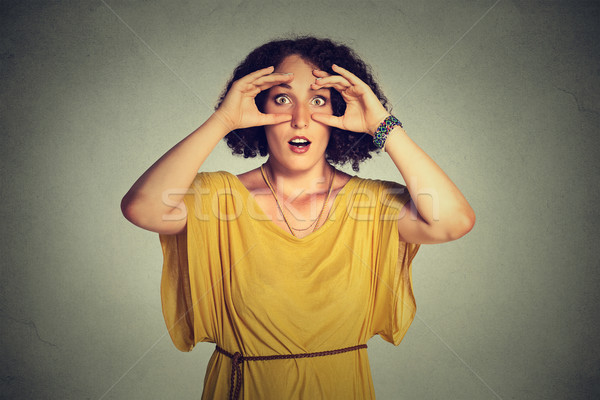 stunned curious woman, peeking looking through fingers like binoculars searching Stock photo © ichiosea