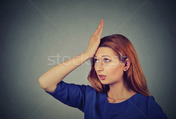 Stock photo: Regrets wrong doing. Silly young woman, slapping hand on head having duh 