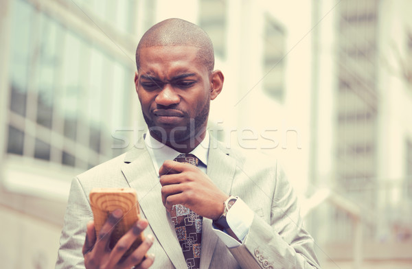 Unhappy young man talking texting on cellphone outdoors Stock photo © ichiosea