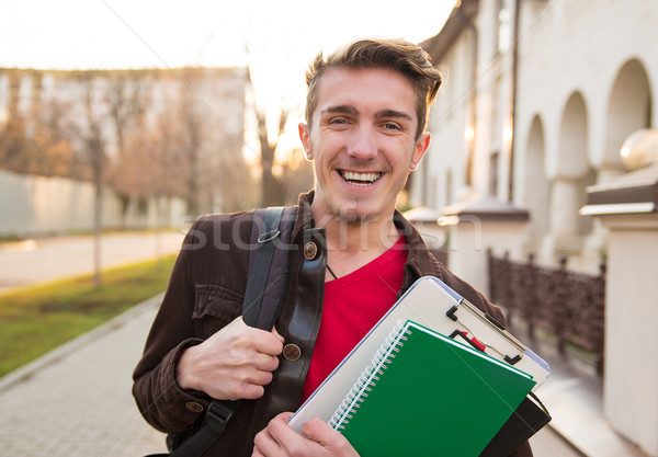 Cheerful man with books walking on street Stock photo © ichiosea