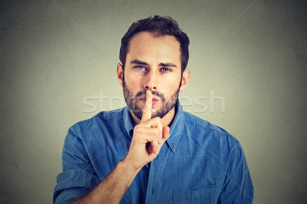 man giving Shhhh quiet, silence, secret gesture isolated on gray wall background   Stock photo © ichiosea