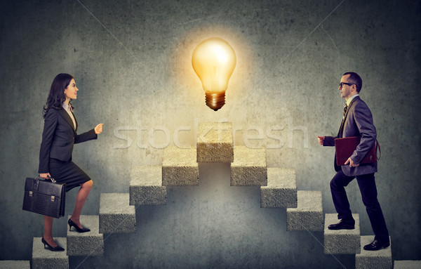 Business people climbing stepping up a stairway career ladder with idea light bulb on a top  Stock photo © ichiosea