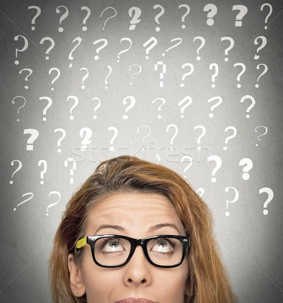 woman with puzzled face expression and question marks above head Stock photo © ichiosea