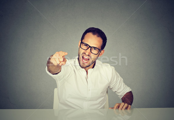 Angry businessman sitting at his desk and screaming Stock photo © ichiosea