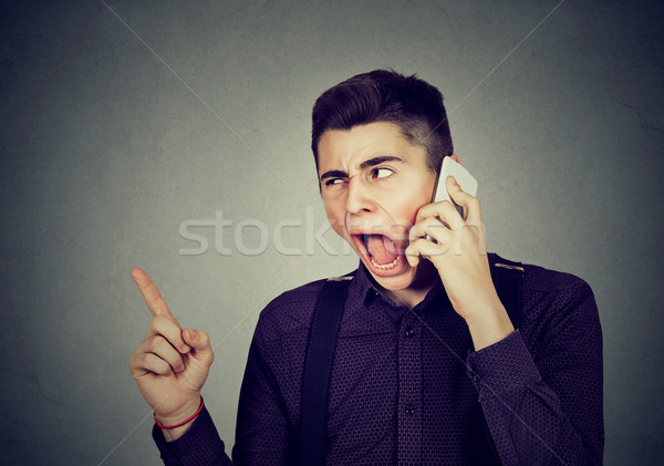 angry young man screaming on mobile phone Stock photo © ichiosea