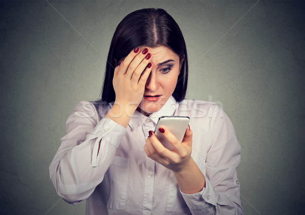 Upset shocked serious woman looking at her mobile phone. Stock photo © ichiosea