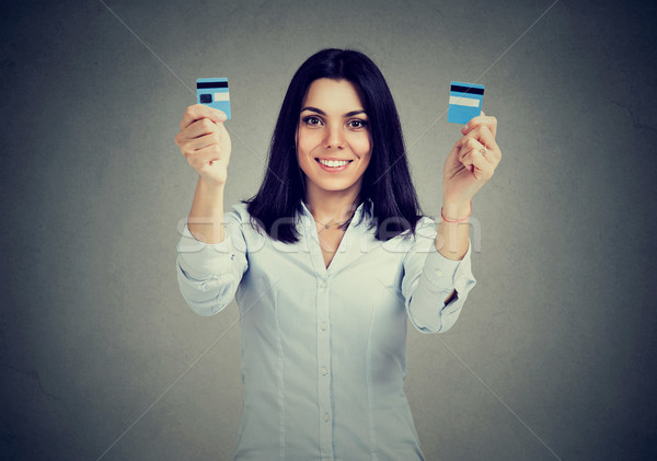 Happy debt free woman holding a credit card cut in two pieces Stock photo © ichiosea