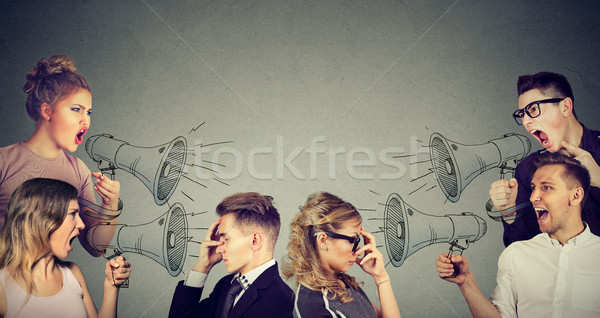 Group of people men and women screaming in megaphones at sad depressed couple  Stock photo © ichiosea