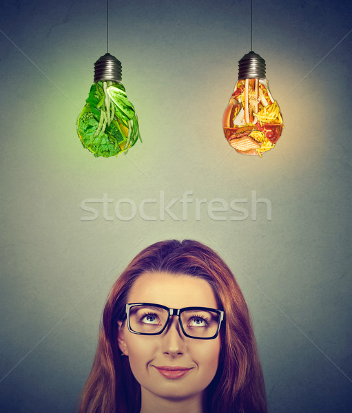Woman thinking looking up at junk food and green vegetables light bulbs Stock photo © ichiosea