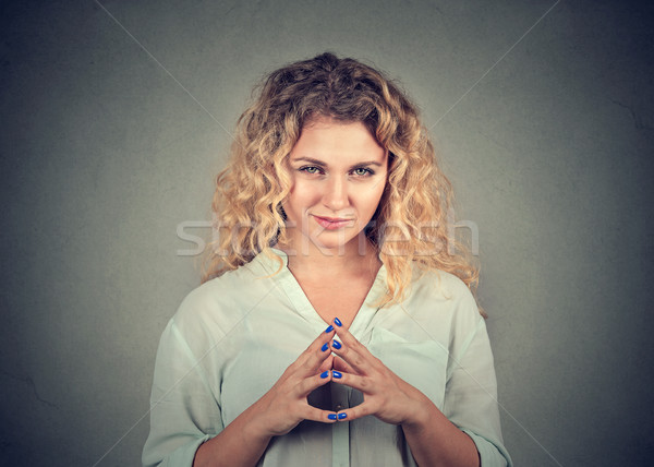Stock photo: sneaky, sly, scheming young woman plotting something 