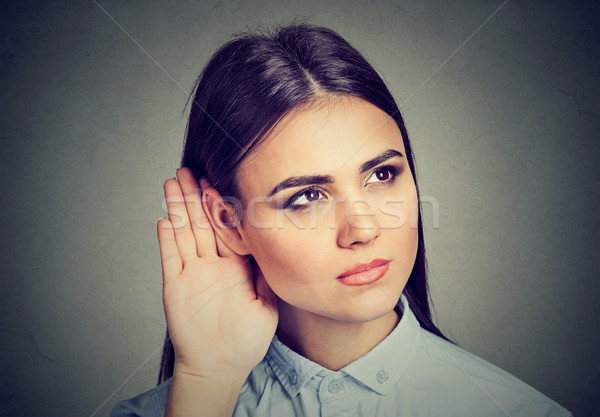 Woman with hand to ear gesture listening carefully Stock photo © ichiosea